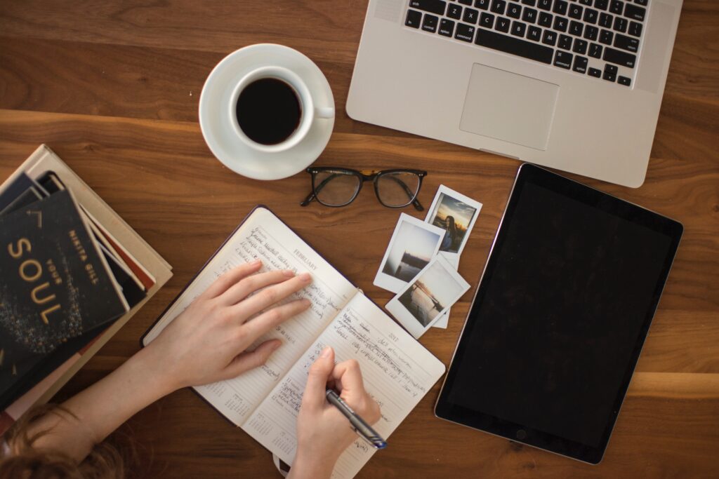 person holding ballpoint pen writing on notebook, brand your blog