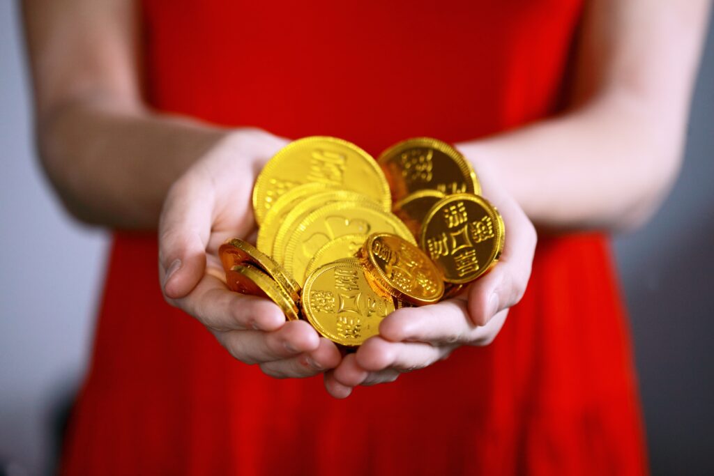 person holding gold-colored ching coins financial planning for kids