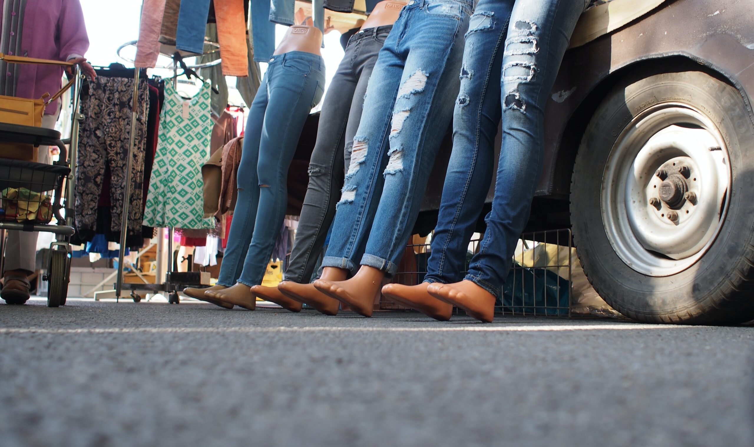 woman in blue denim jeans and brown leather shoes sitting on black metal bench during daytime